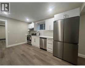 A kitchen with a refrigerator, stove, and sink.