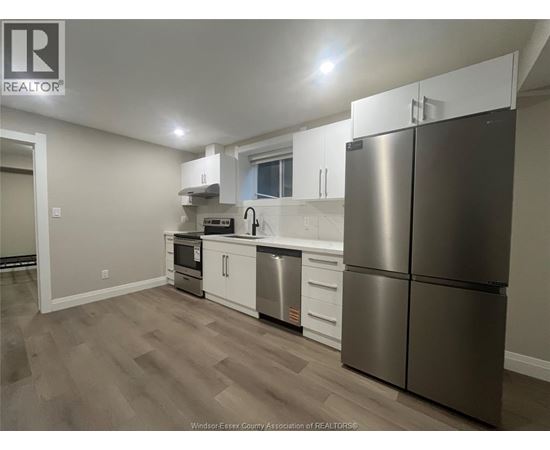 A kitchen with a refrigerator, stove, and sink.