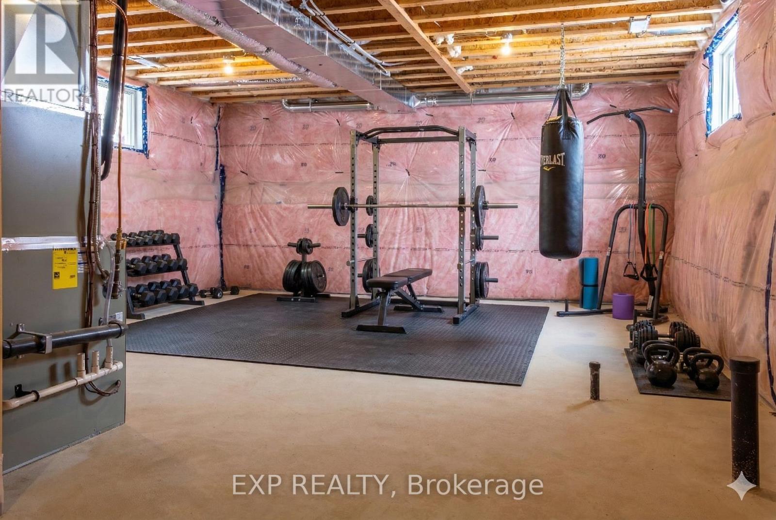 A gym with a punching bag, weights, and exercise equipment.