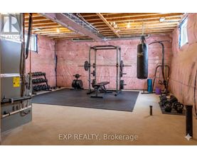 A gym with a punching bag, weights, and exercise equipment.
