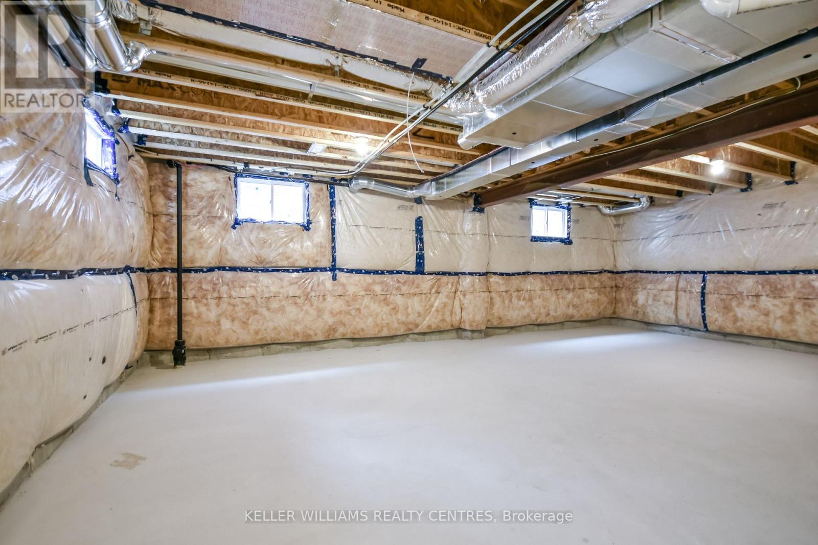 A spacious basement with insulation and pipes.