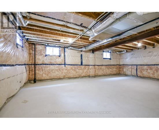 A spacious basement with insulation and pipes.