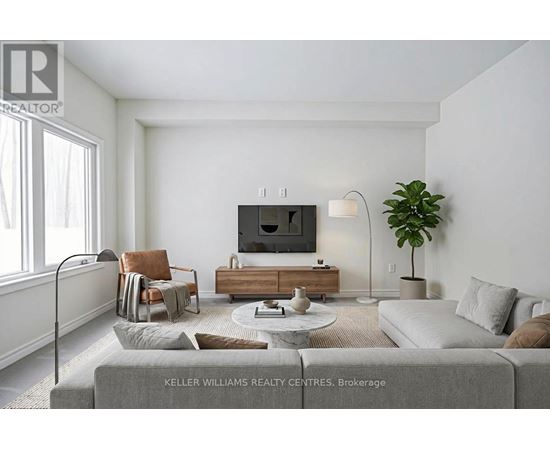 A living room with a grey couch, a wooden coffee table, a flat screen TV, a potted plant, and a window with white curtains.