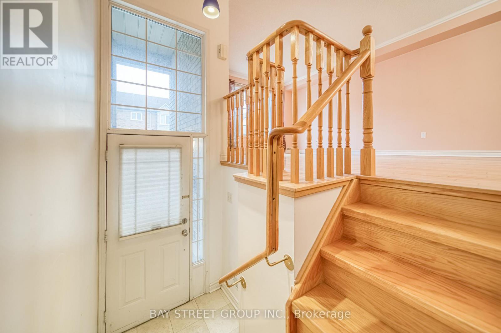 A wooden staircase with a white door and window.