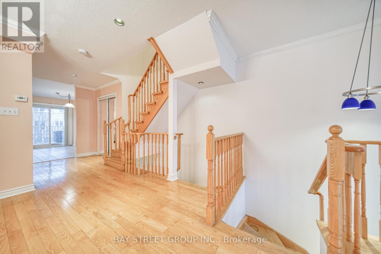 A spacious room with wooden floors and a staircase.