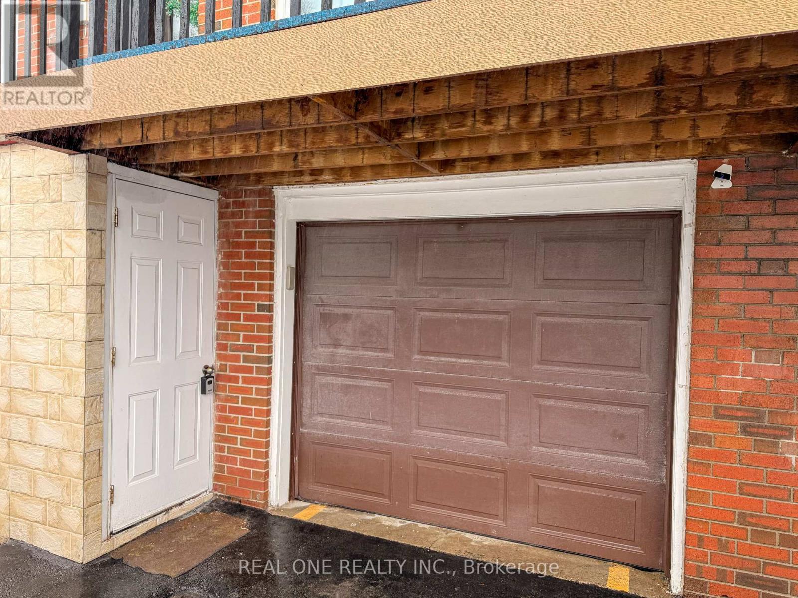 A brown garage door is on the right and a white door is on the left.