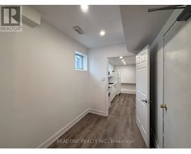 A white room with a window and a door leading to another room.