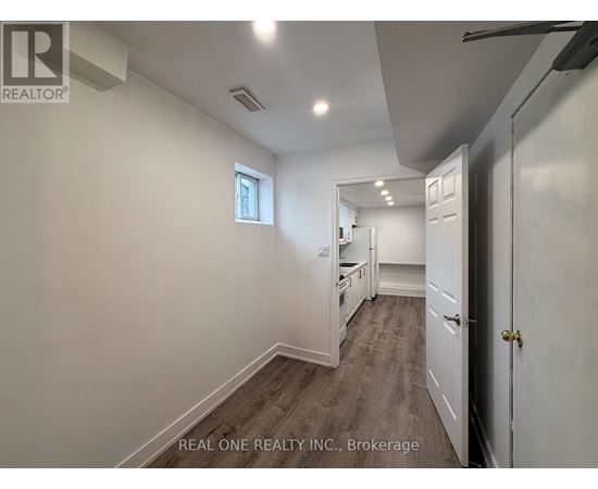 A white room with a window and a door leading to another room.