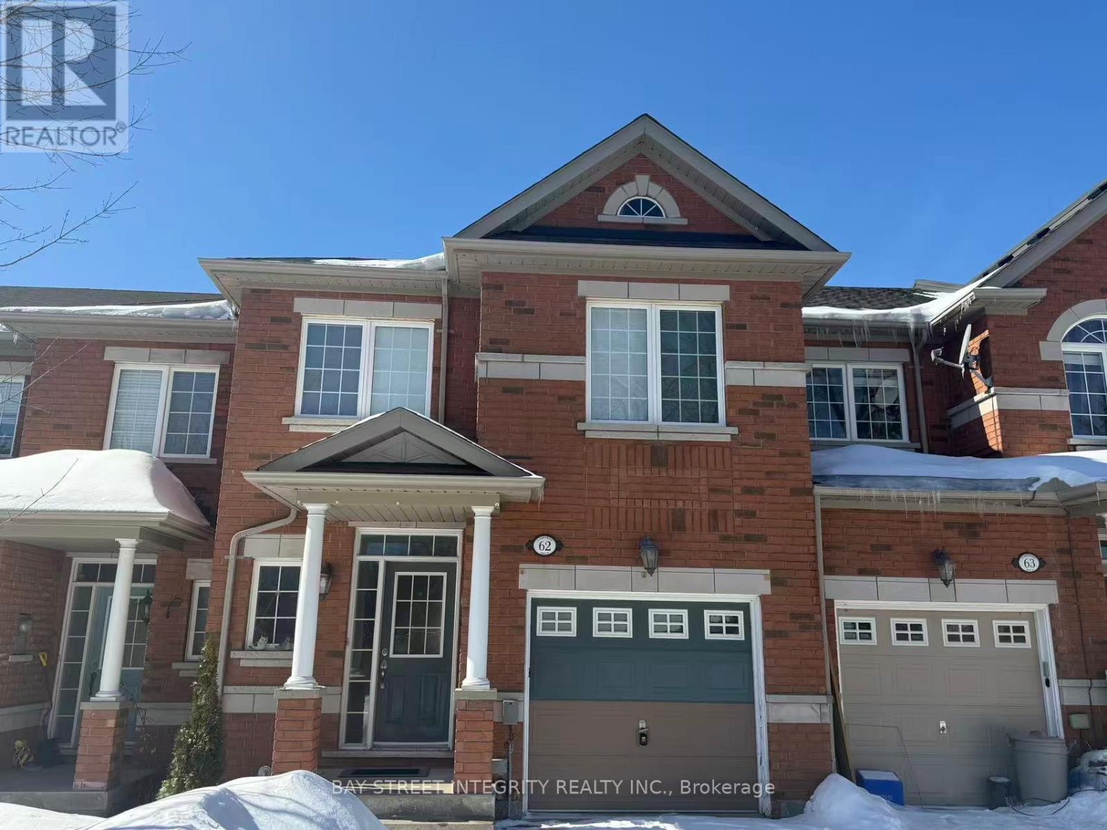 A large brick house with a bay window and a garage door.