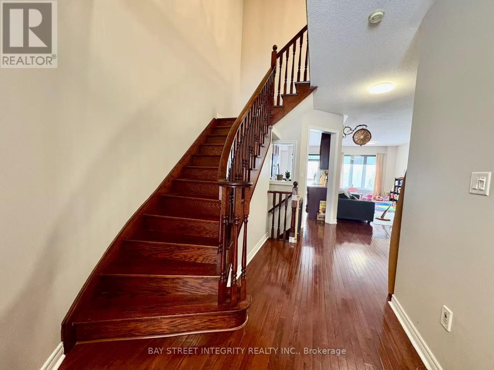 A wooden staircase in a home with a white wall.