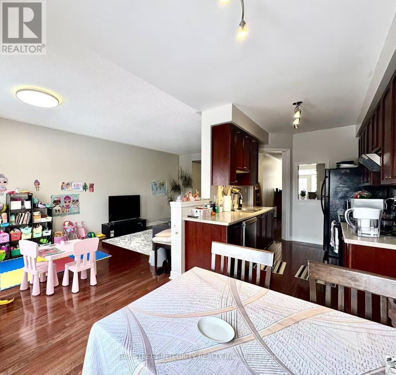 A bedroom with a bed in the foreground and a kitchen area in the background.