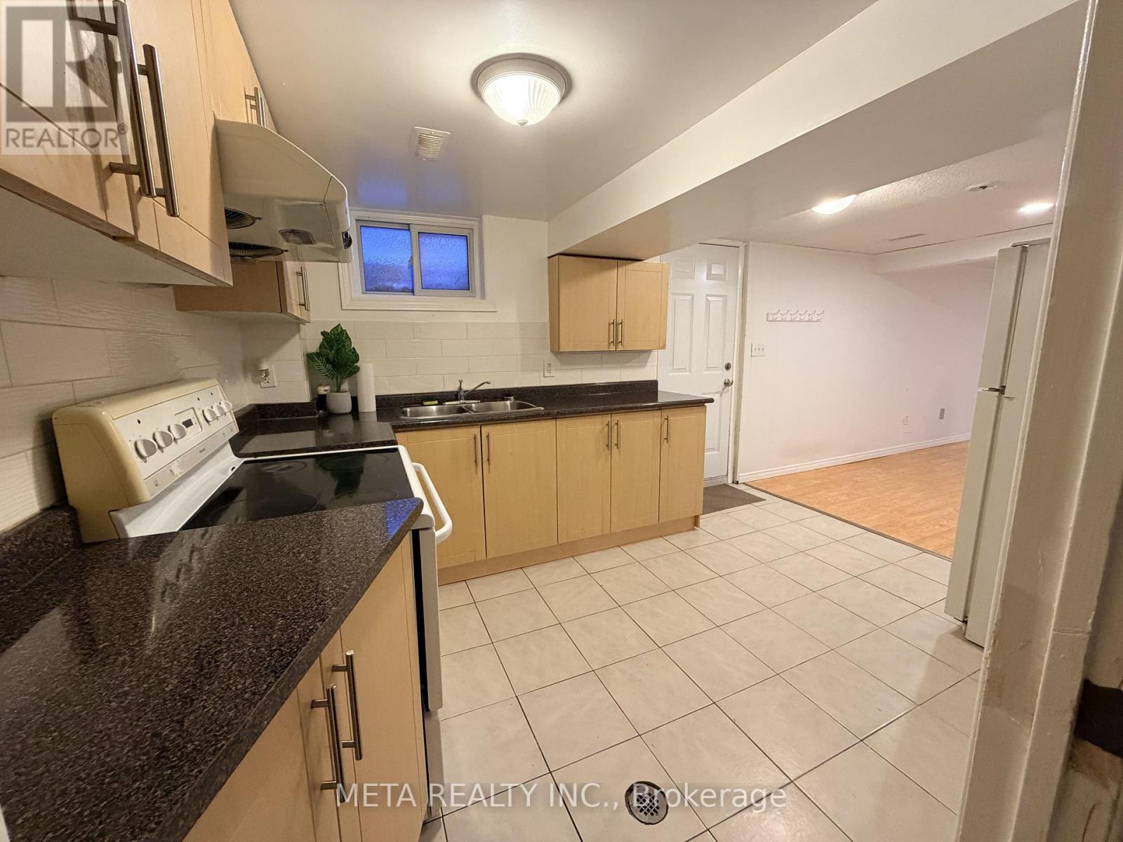 A kitchen with a granite countertop and wooden cabinets.