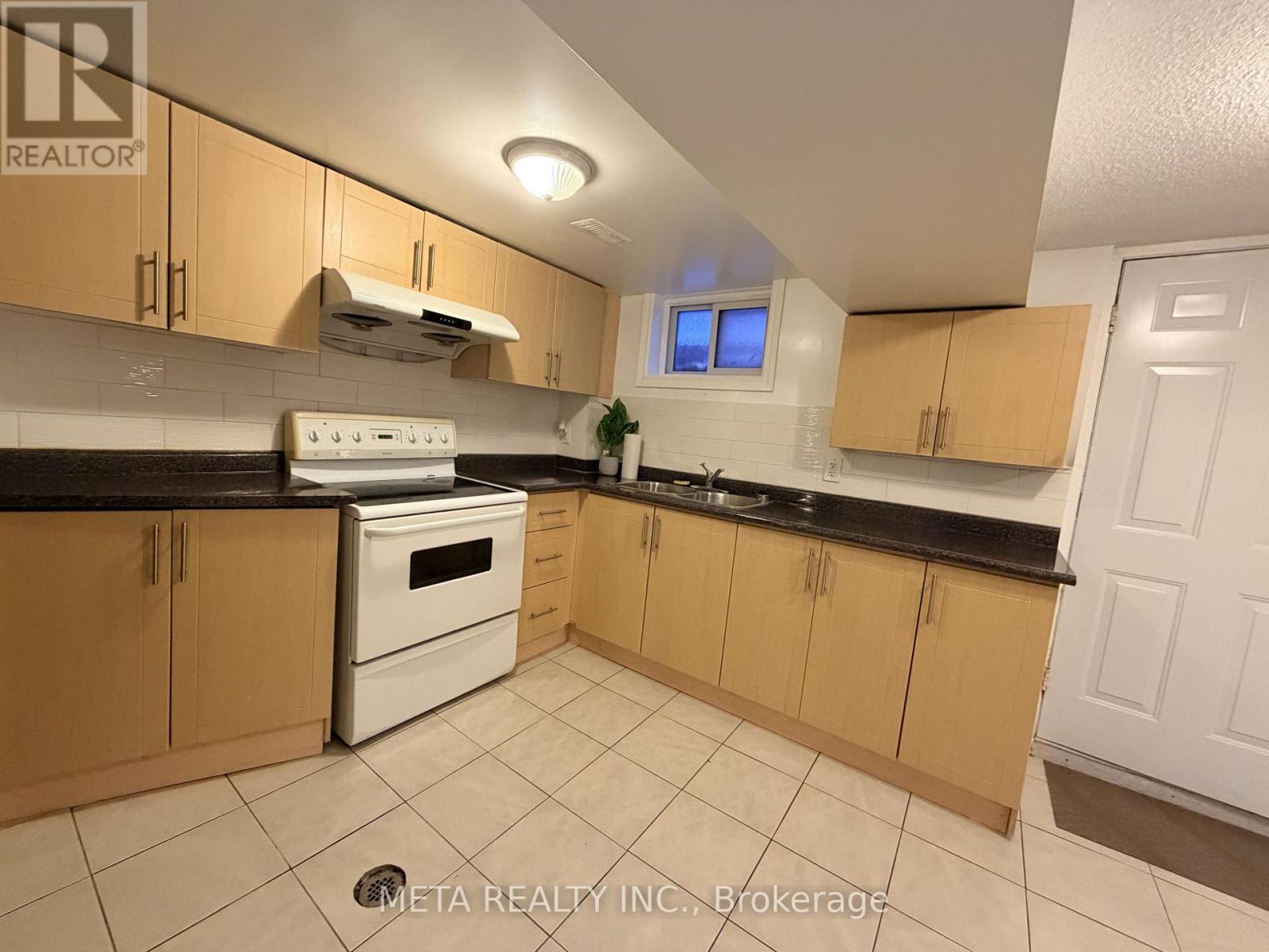 A kitchen with wooden cabinets and a white stove top oven.
