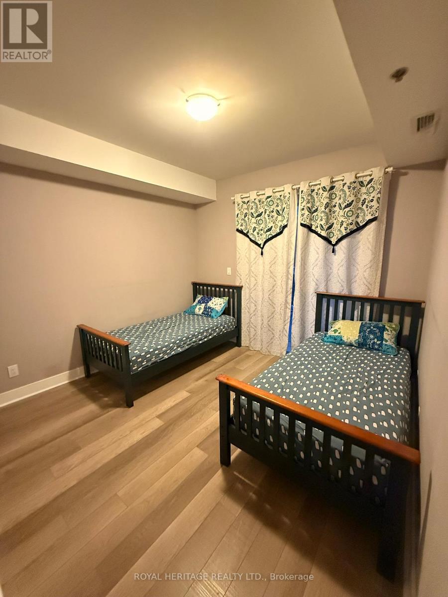 A bedroom with two beds and wooden floors.