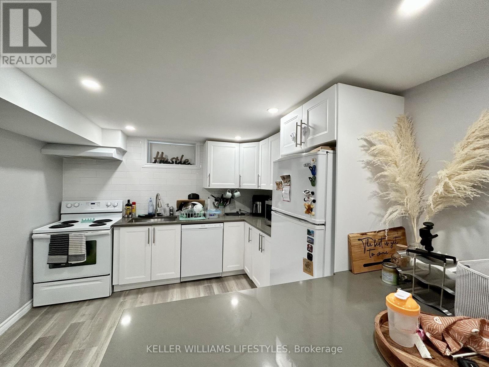 A well-lit kitchen with white cabinets and a wooden tray on the counter.