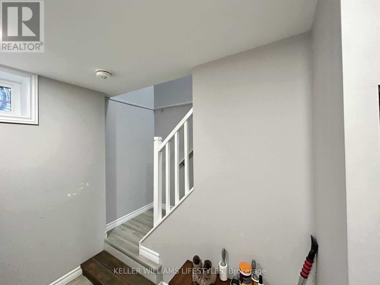 A staircase with a white railing and a brown mat on the floor.
