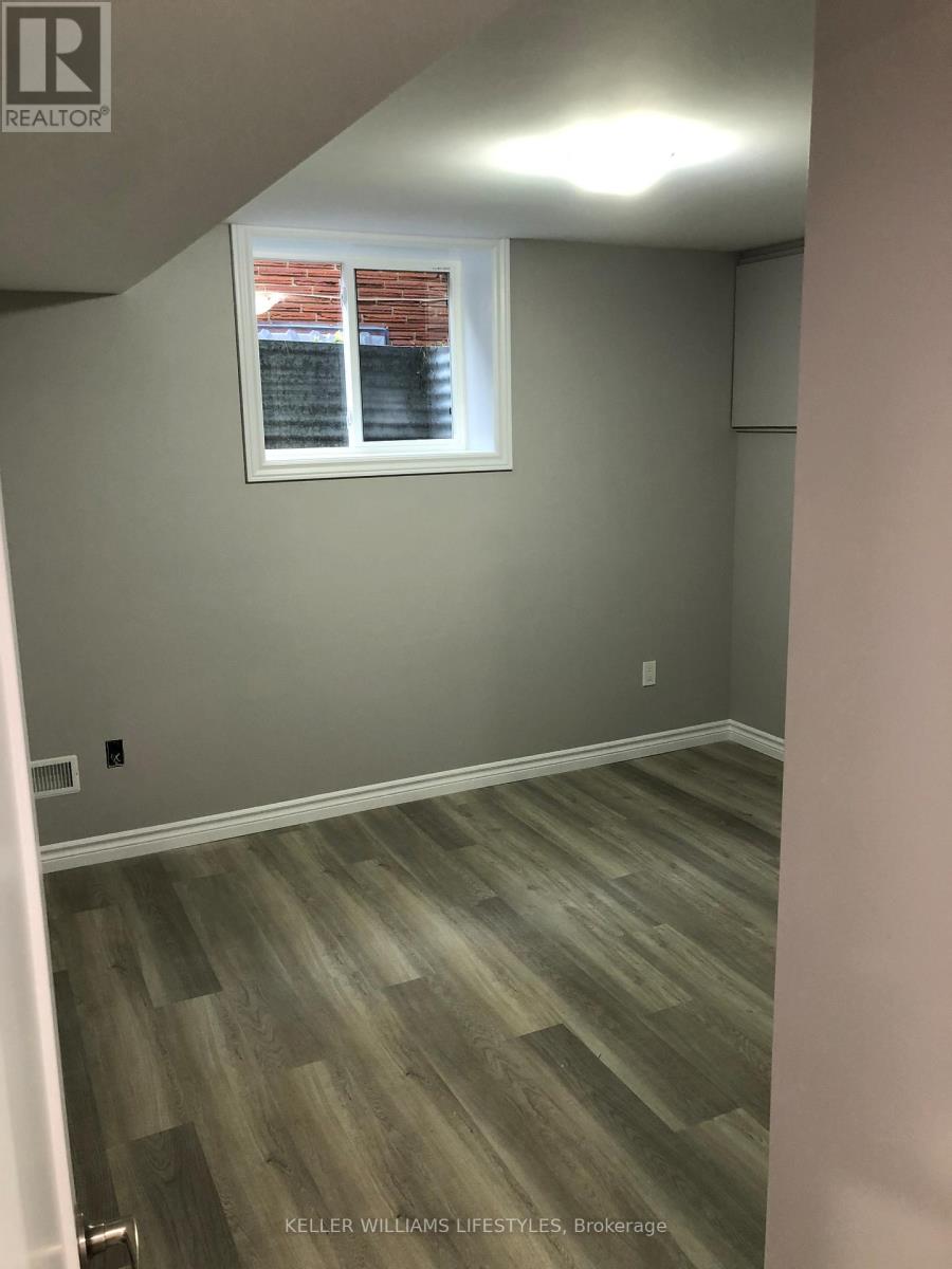 A room with a window and a wooden floor.