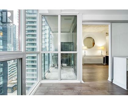 A modern interior space with a view of a cityscape through large windows.