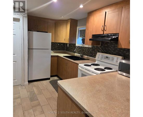 A kitchen with a white fridge and stove top oven.