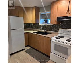 A kitchen with a white fridge, white stove, and wooden cabinets.