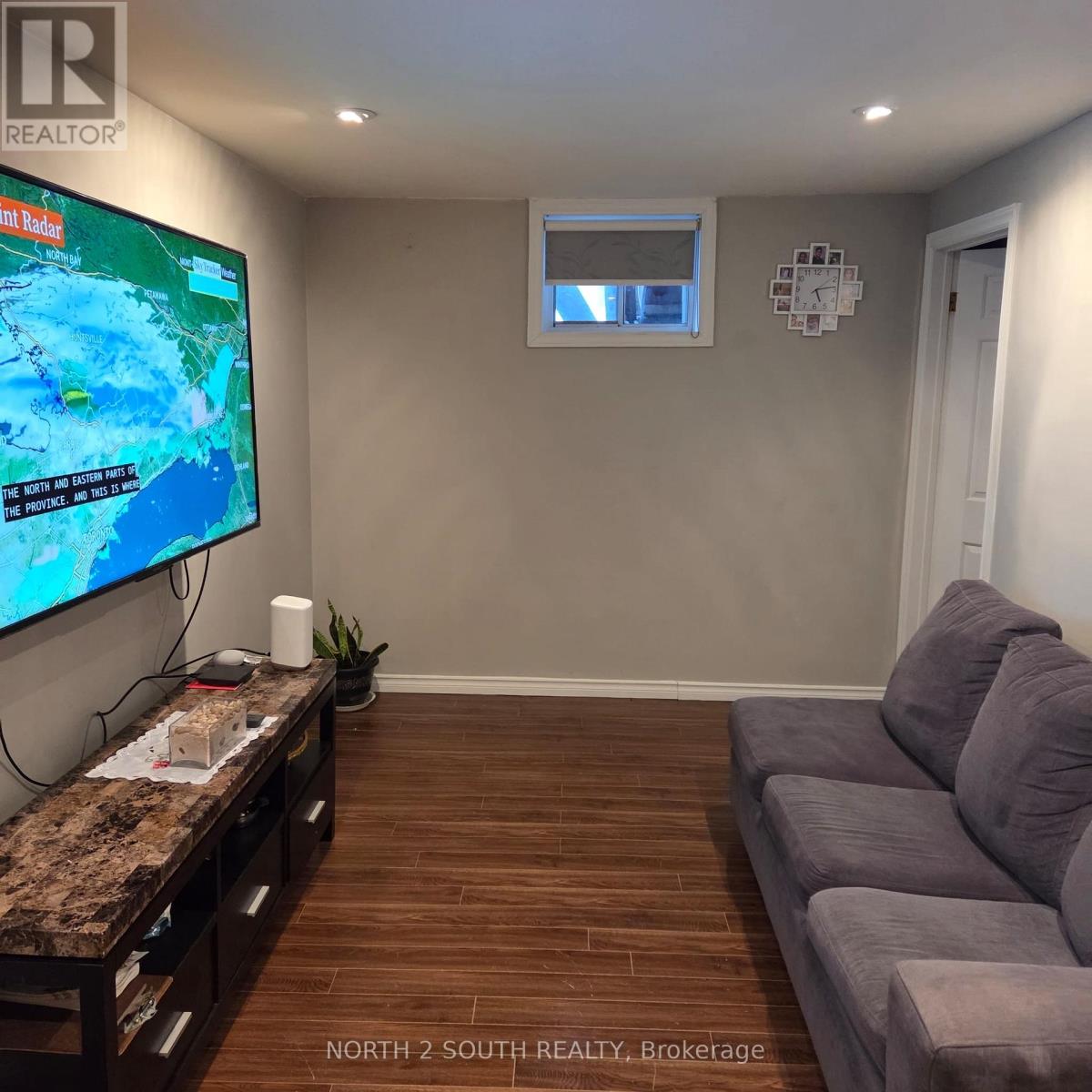 A living room with a flat screen TV and a couch.