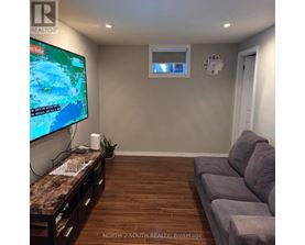 A living room with a flat screen TV and a couch.