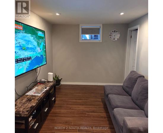 A living room with a flat screen TV and a couch.