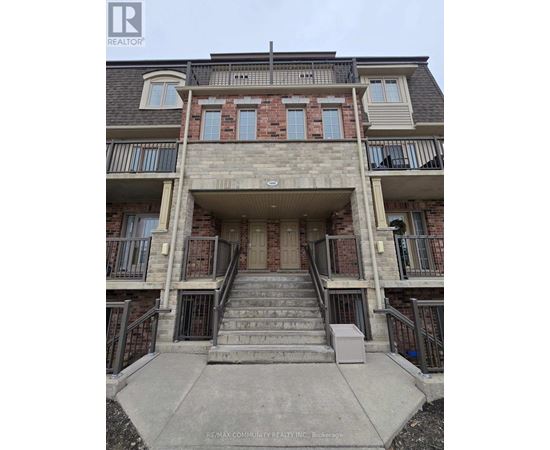 A multi-story apartment building with a balcony on the second floor.