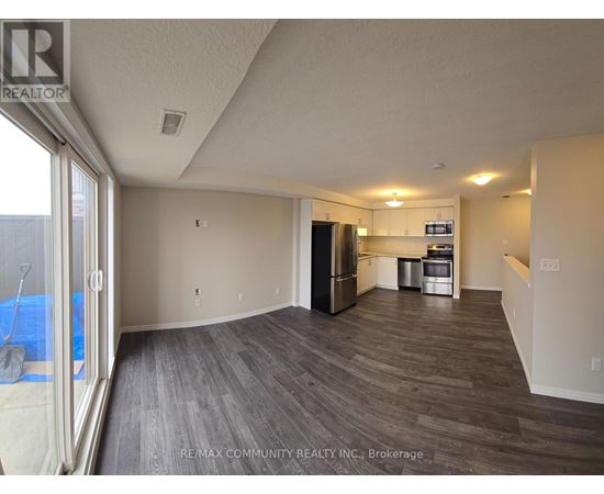 A spacious room with a kitchenette and a view of a pool through a glass door.