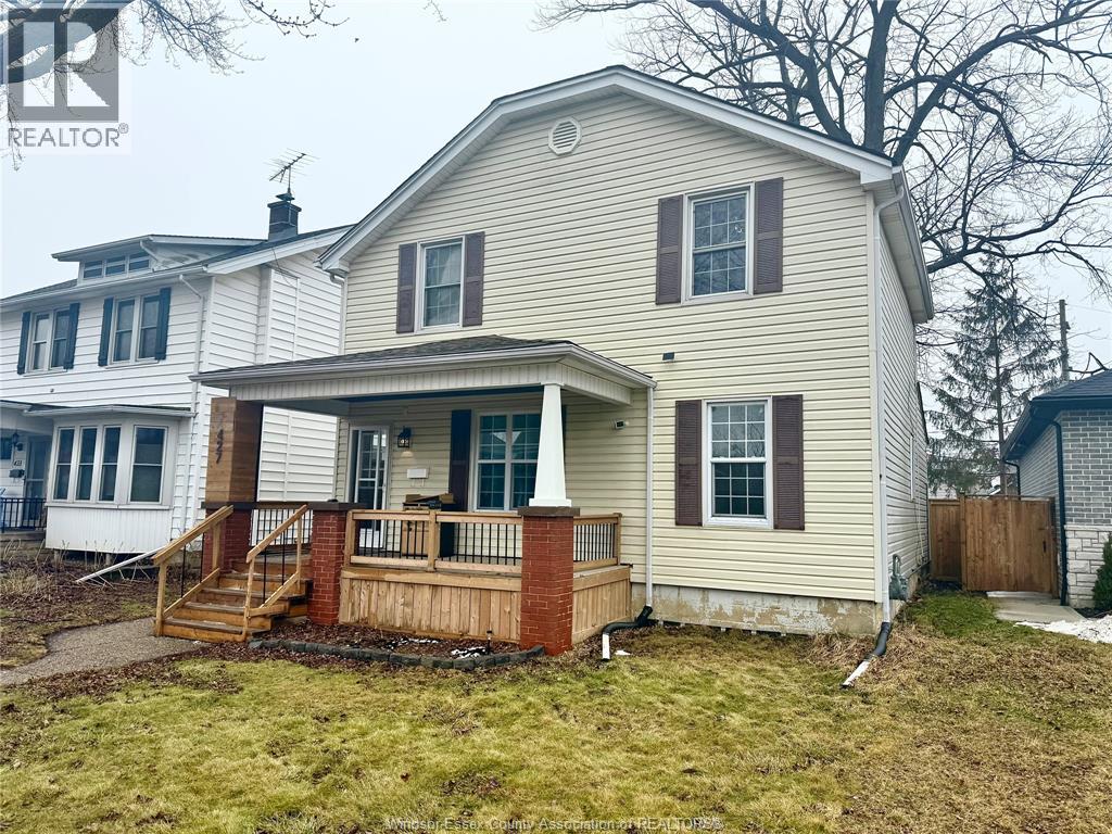 A house with a front porch and a brown fence.