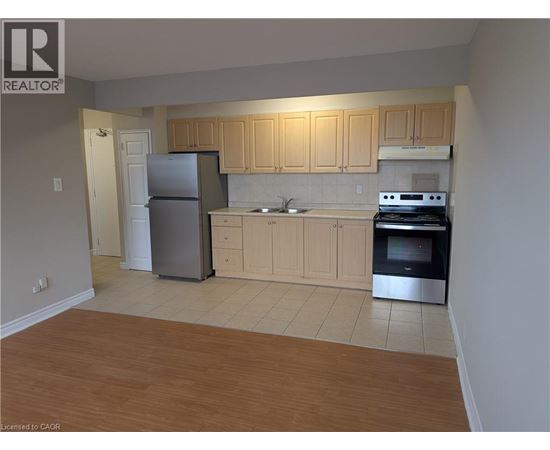 A kitchen with wooden cabinets and a refrigerator.