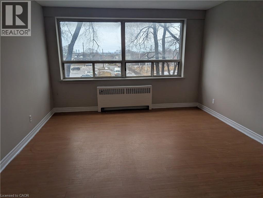 A room with a window and a radiator on the floor.