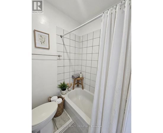 A white bathroom with a tub, toilet, and sink.