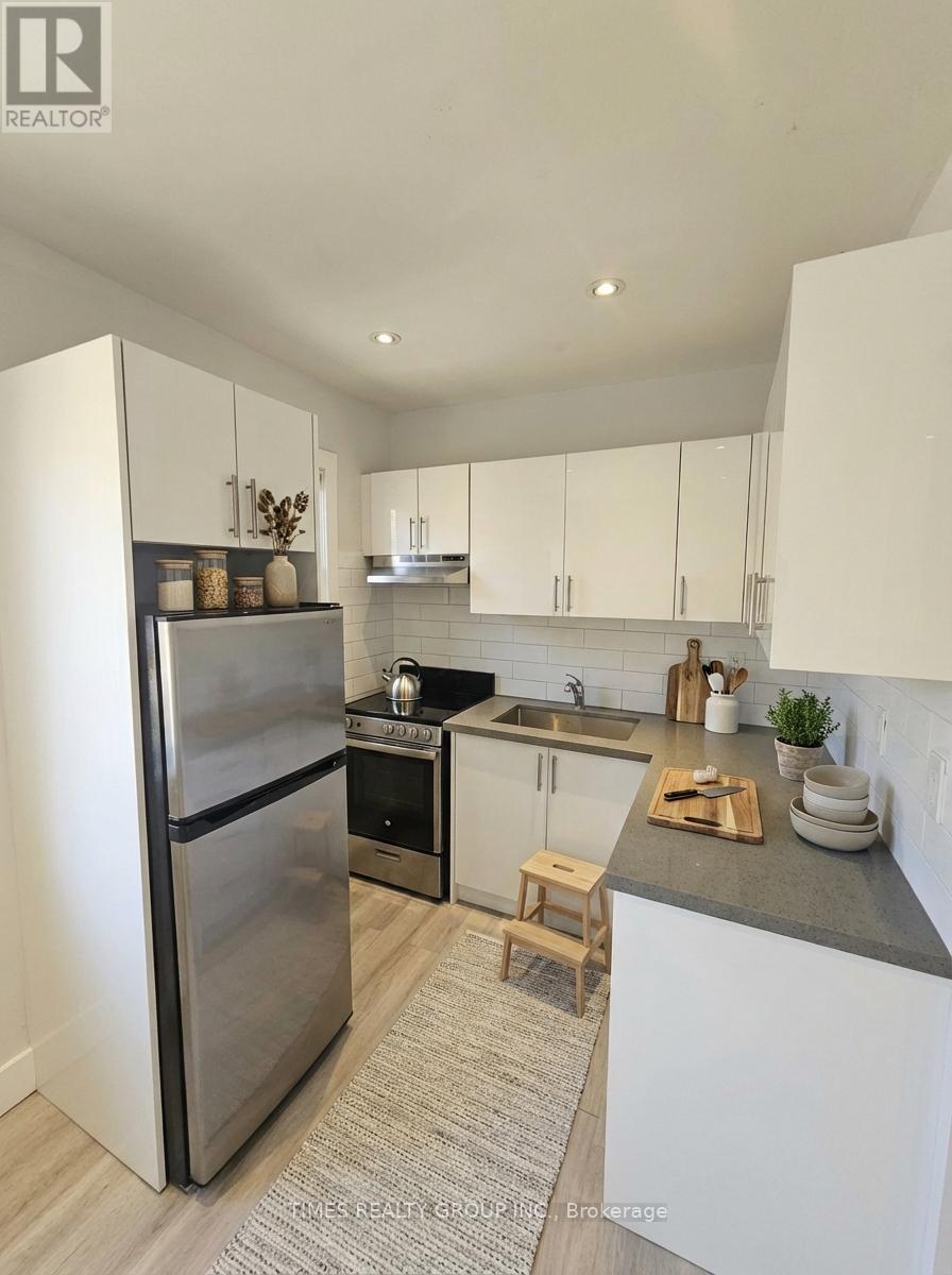 A modern kitchen with a stainless steel refrigerator and white cabinets.