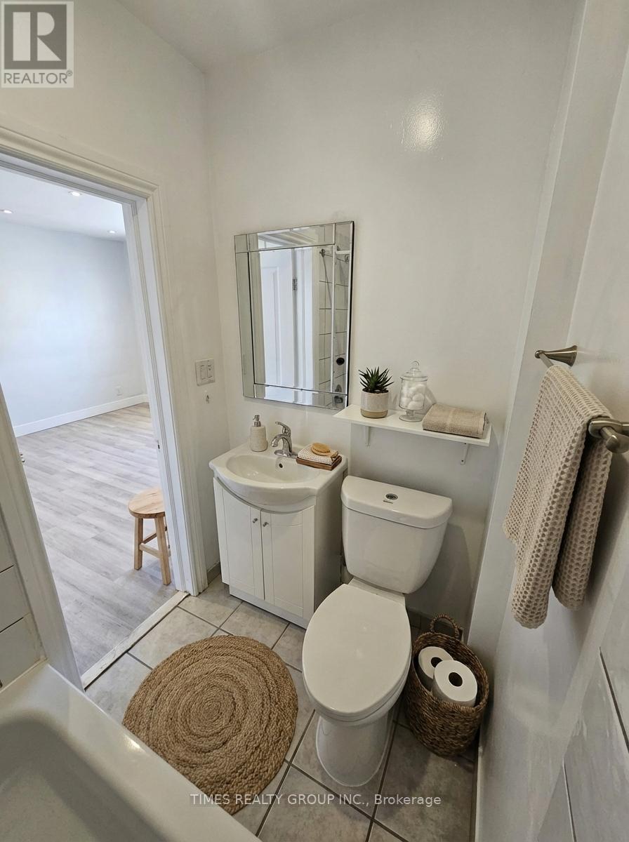 A white bathroom with a toilet, sink, and mirror.