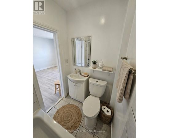 A white bathroom with a toilet, sink, and mirror.