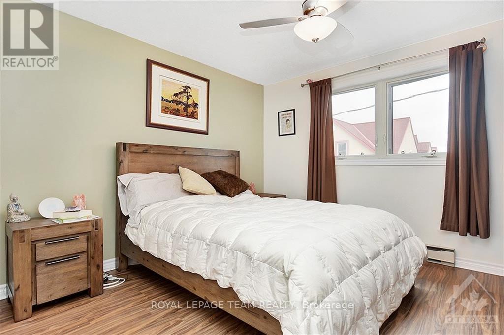 A bedroom with a bed, nightstand, and window.