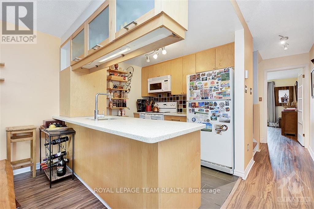 A kitchen with a white counter top and wooden cabinets.