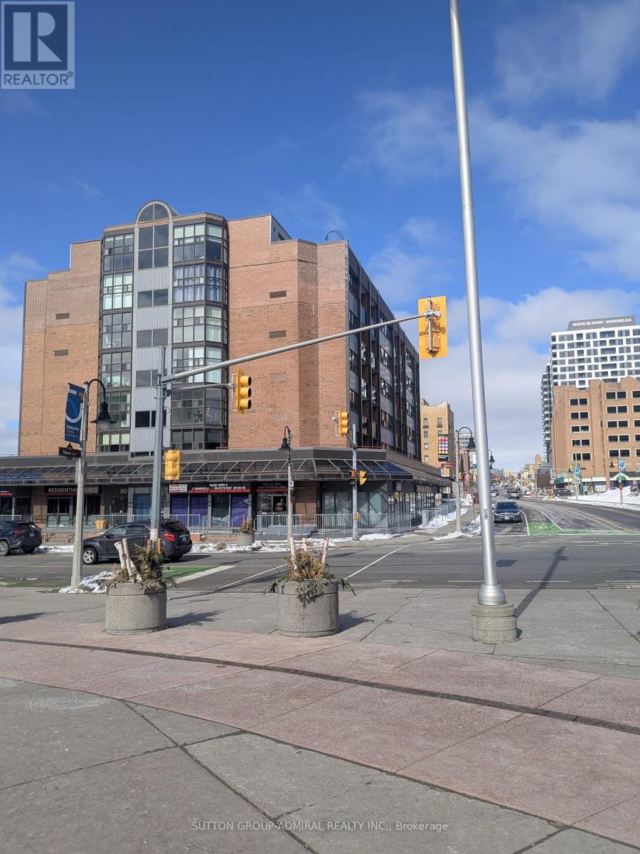 A street view with a building in the background and a traffic light on the right.