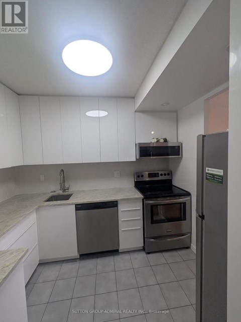 A kitchen with white cabinets and a stainless steel dishwasher and oven.