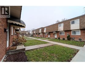 A row of houses with a Realtor sign in the foreground.
