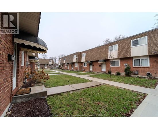 A row of houses with a Realtor sign in the foreground.