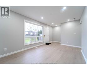 A spacious room with a large window and a door leading to a balcony.