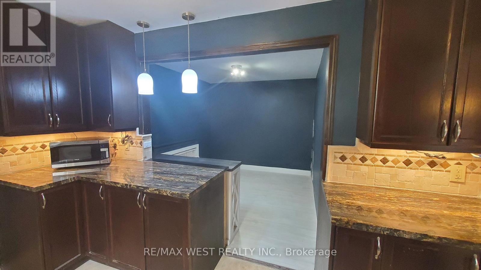 A kitchen with dark wood cabinets and a countertop with a paper on it.