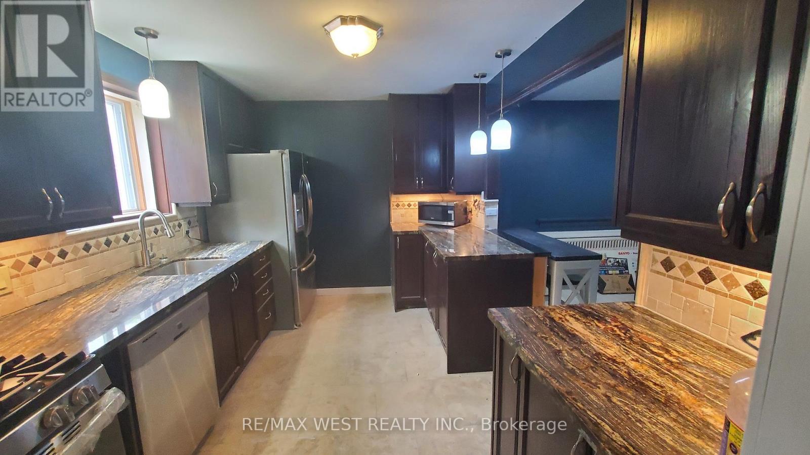 A kitchen with a stove top oven and a refrigerator.