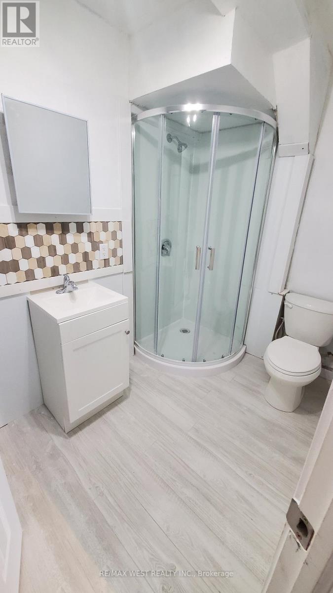 A white bathroom with a glass shower stall and a toilet.