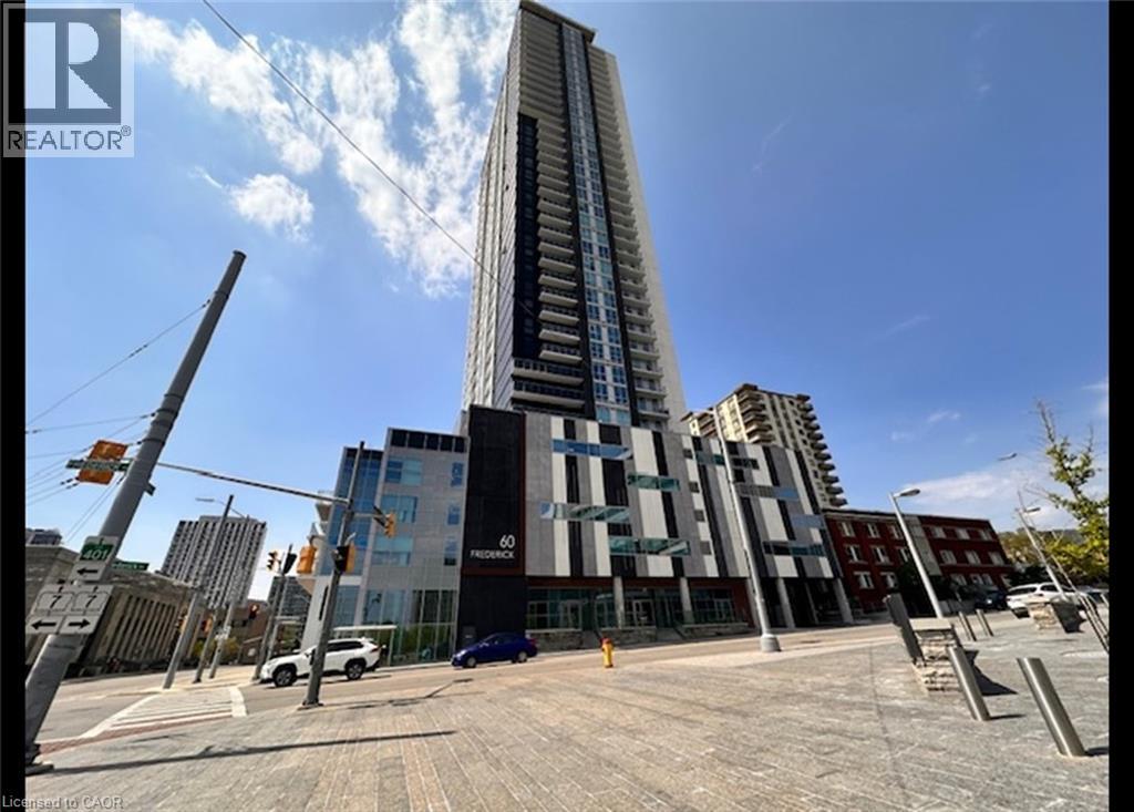 A tall building with a glass facade stands in the middle of a city street.