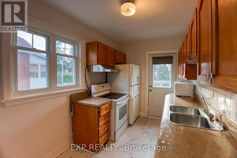 A kitchen with wooden cabinets and a stove top oven.