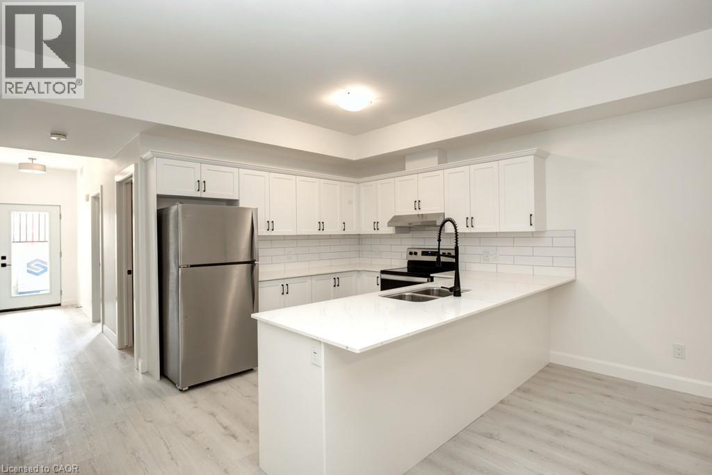 A kitchen with white cabinets and a stainless steel refrigerator.