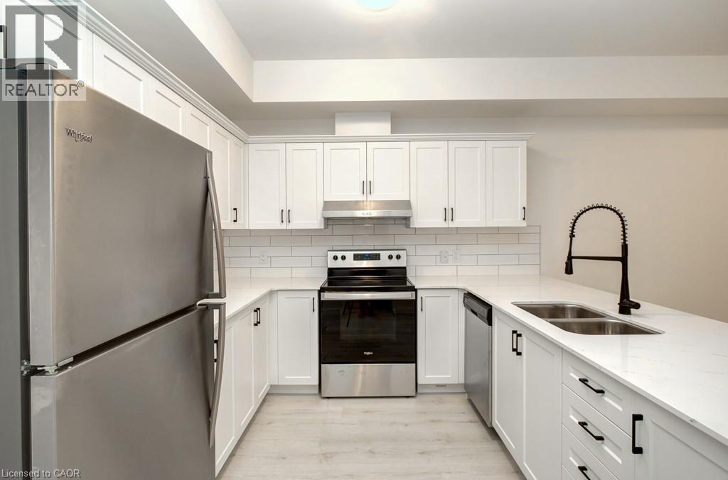 A kitchen with white cabinets and a stainless steel refrigerator.